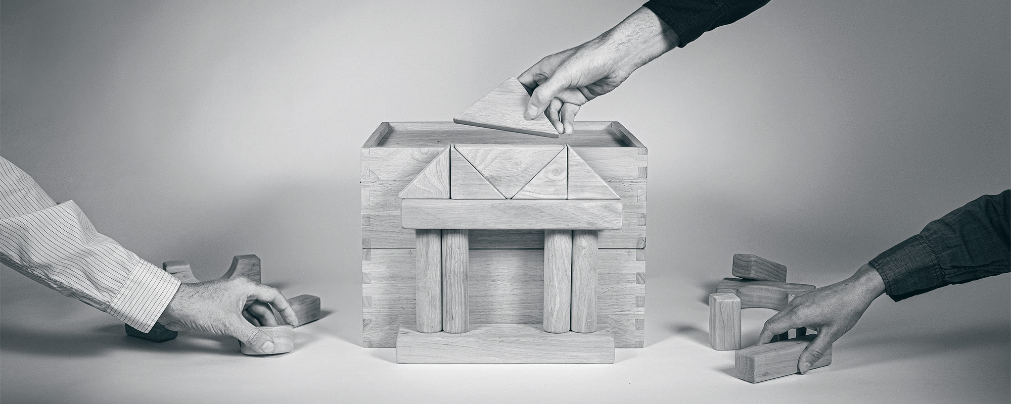 Image of hands working together to build a financial institution.