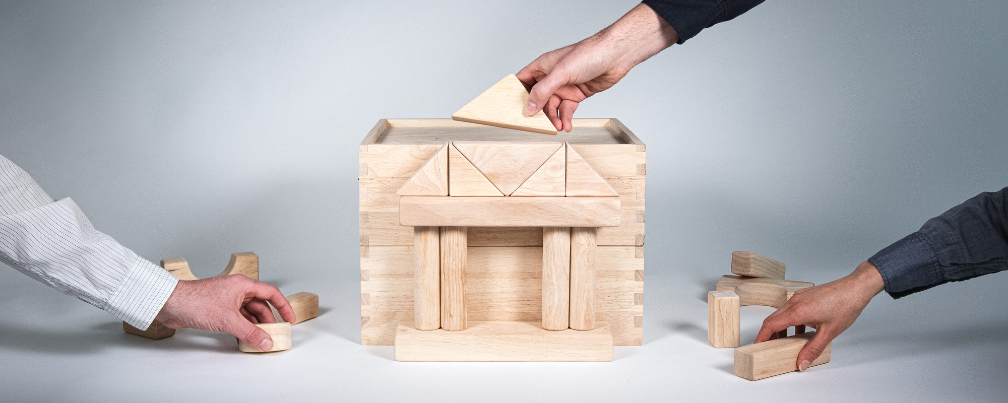 Image of hands working together to build a financial institution.
